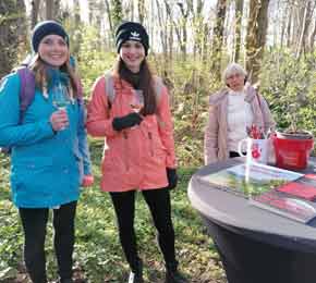 Mädchen stehen mit Sektglas vor einem Tisch